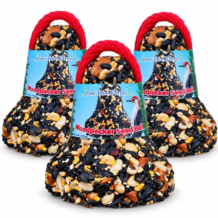 Three Pine Tree Farms Woodpecker Seed Bells with blue labels and red hanging loops on a white background.