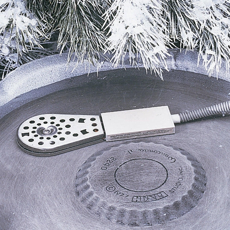 Deluxe Birdbath Heater on a concrete surface. Close-up of stainless steel housing and circular design, ideal for keeping birdbath water ice-free in cold weather.