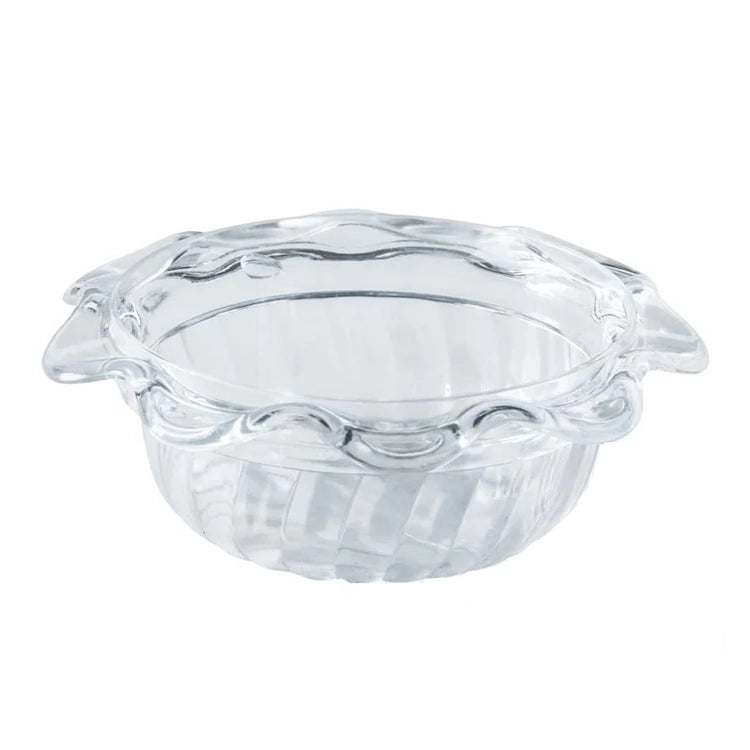 Clear glass pie dish with decorative rim on a white background