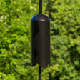 Black cylindrical Squirrel Guard mounted on a garden stake; vaporizes repellent mat to create bug-free zone. Durable, weather-resistant steel, fits various pole sizes.