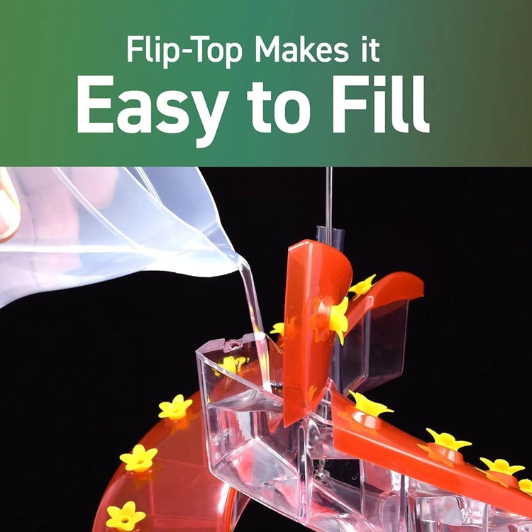 Clear plastic device with red flip-top being filled with a white liquid, against a black background.