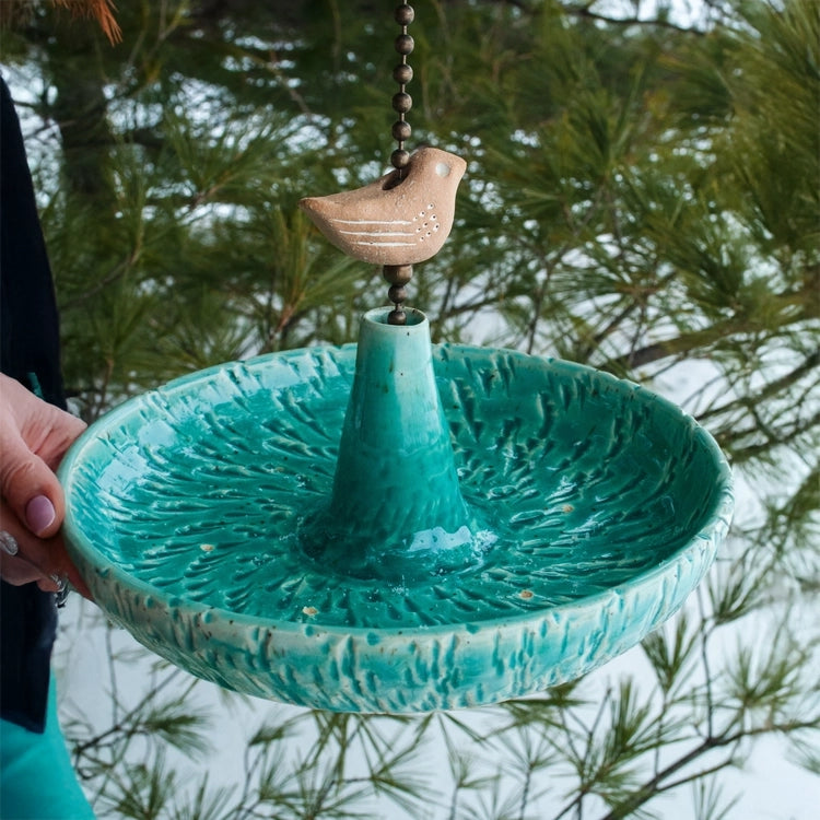 Platter Bird Feeder held in hand, showcasing its textured edge and durable stoneware, ideal for inviting birds.