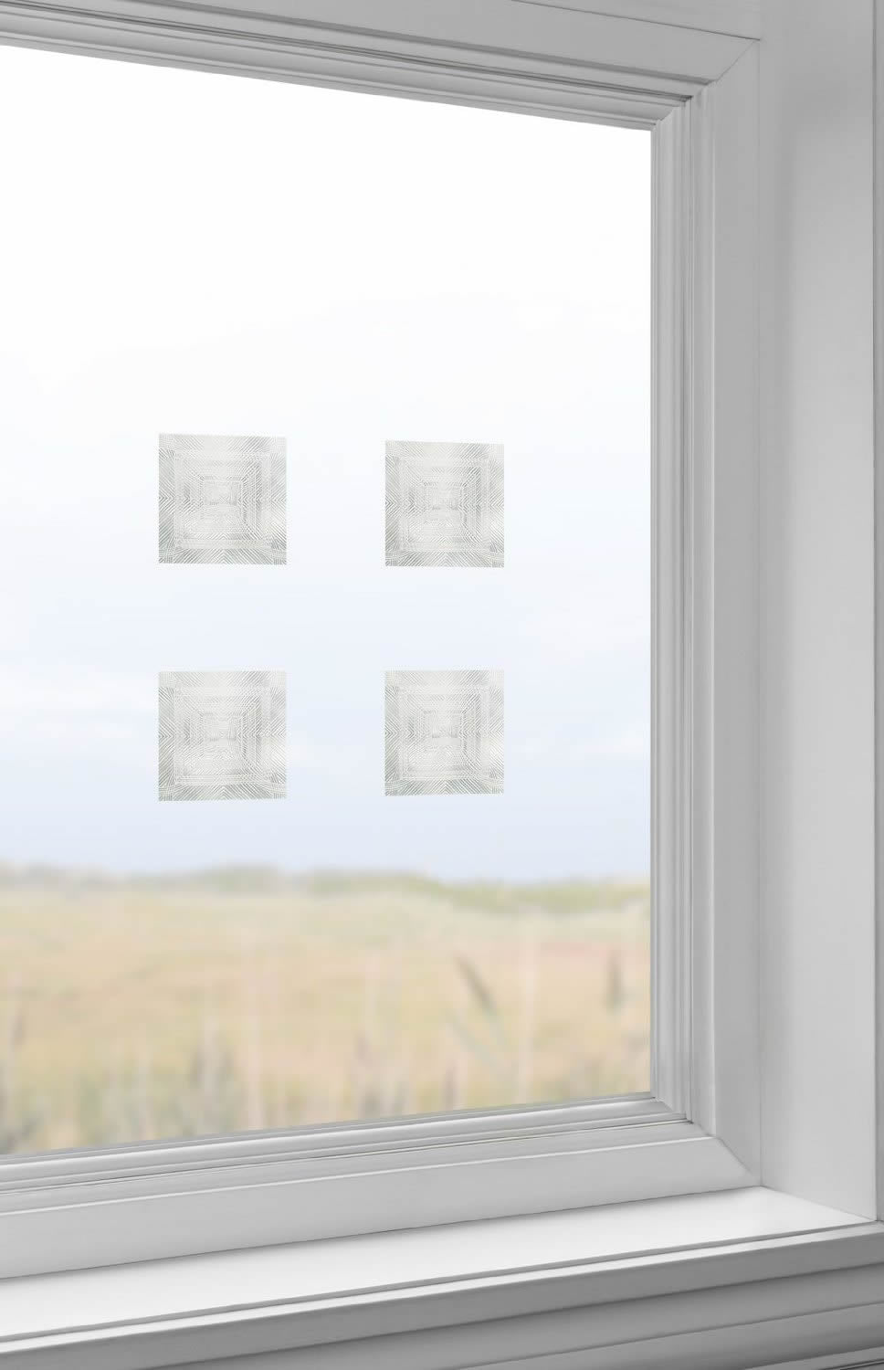 4 x 4 Clear & Etched Bird Deflector, Pack of 6, displayed on a window, showcasing the translucent, geometric pattern designed to prevent bird collisions.