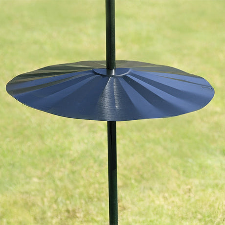 Superwide Pole Baffle clamped on a vertical pole over grass, designed to deter squirrels with its 23-1/2 inch diameter, easy wraparound design.