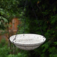 Avistry Hanging Bird Bath with speckled ceramic design, suspended by a metal chain, elegantly integrates into outdoor spaces, attracting birds with its welcoming feature.