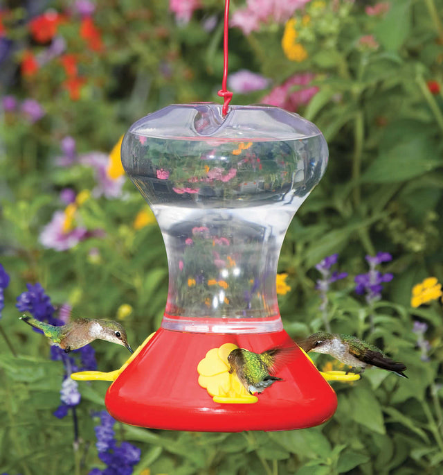 Fliteline Hummingbird Feeder with 30 oz. capacity, featuring three feeding stations and bee guards, shown with a hummingbird feeding from the yellow flower port.