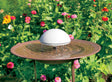 Water Wiggler in a birdbath, featuring a white dome and metal legs, creating ripples to attract birds and prevent mosquitoes.