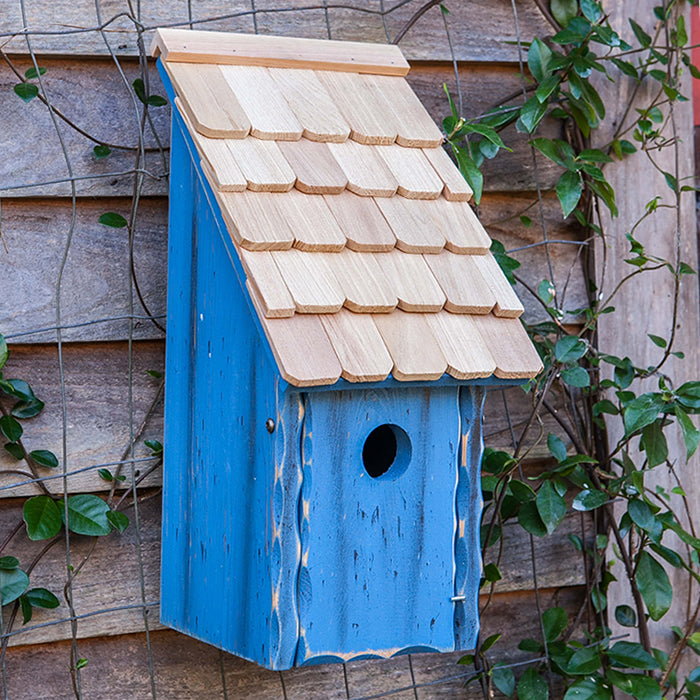 Bluebird Bunkhouse: A wooden birdhouse with a shingled roof and front panel that opens for cleaning, featuring a 1-1/2 inch entry hole.