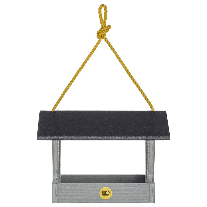 Modern Farmhouse Fly-Thru Bird Feeder, Driftwood, hanging from a yellow rope, features a black roof and durable mesh screen for drainage.