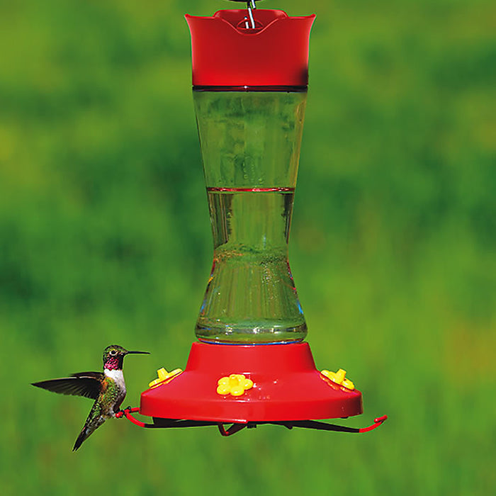 Pinch Waist Hummer Feeder with decorative clear glass vase, red cap and bottom, yellow feeding ports, and four feeding stations.