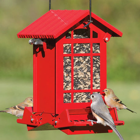 Chateau Squirrel-Resistant Feeder with birds perched on two feeding trays, displaying weight-activated perches and clear plastic windows for seed visibility.