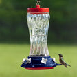 Patriotic Swirl Hummingbird Feeder with glass reservoir, red plastic cap, six feeding ports, and wide mouth opening for easy filling and cleaning.