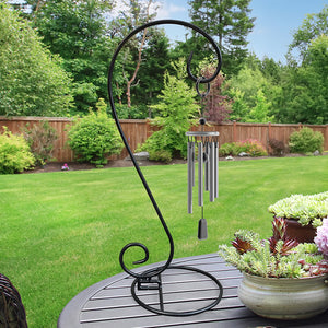 Universal 26 Tabletop Stand on a table with a wind chime hanging, surrounded by potted succulents and garden elements.