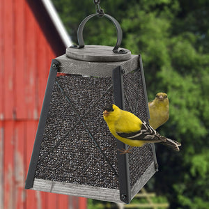 Rustic Farmhouse Wood & Mesh Nyjer® Seed Feeder with a yellow bird perched, showcasing its sturdy metal mesh design and ample clinging space for easy bird feeding.