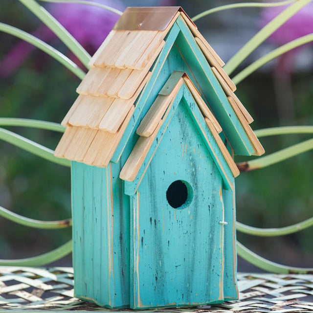 Bluebird Brights: A wooden birdhouse with a small entry hole, shingled roof, and copper peak, designed for easy cleaning and nest inspection.