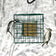 Duncraft Squirrel Proof Suet Sanctuary with tightly woven metal fencing, designed to deter squirrels while allowing birds like woodpeckers to enjoy suet cakes.