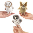 Hands holding Folkmanis Mini Owl Finger Puppets, featuring detailed, huggable owl designs. Finger puppets include Barn Owl, Great Horned Owl, and Spotted Owl for interactive play.