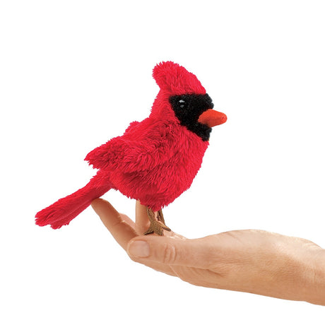 Hand holding Folkmanis Mini Songbird Puppet, designed as a red cardinal, perched on a finger, showcasing its soft, huggable design for kids.