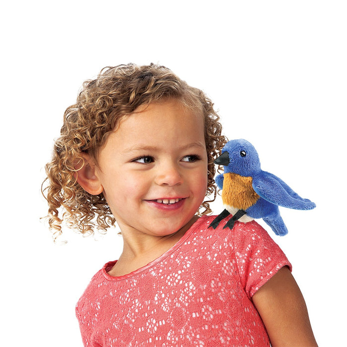 Girl with a bluebird finger puppet on her shoulder, showcasing Folkmanis Mini Songbird Puppets.