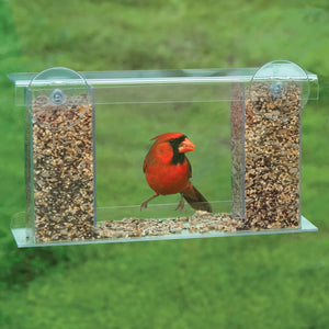 Duncraft Songbird Mirrored Window Feeder featuring a red bird perching on its clear plastic surface with two suction cups and a removable roof.