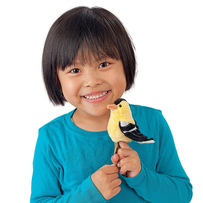 Young girl smiling while holding a Folkmanis Mini Songbird Puppet, designed to look like a backyard bird, easy to animate and perfect for kids.