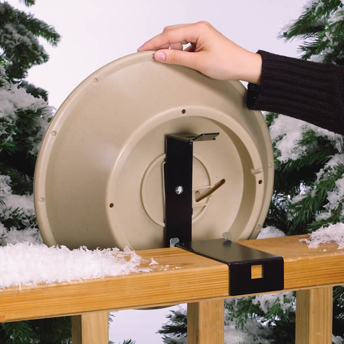 Hand holding a 14 Heated Bird Bath with EZ-Tilt Deck and Pole Mount, showcasing the durable, weather-resistant design for providing birds with water during freezing temperatures.