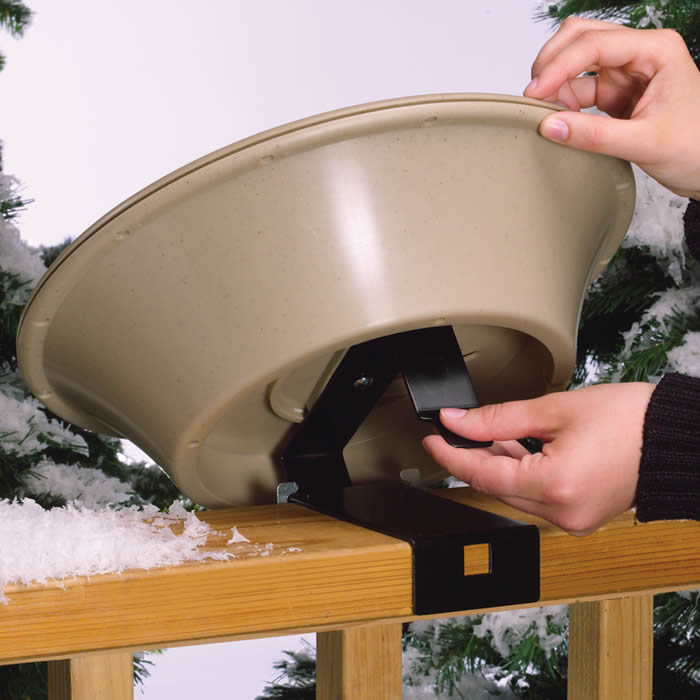 Hand holding the 14 Heated Bird Bath with EZ-Tilt Deck and Pole Mount, designed for year-round use and safety with a thermostatically controlled, weather-resistant plastic build.