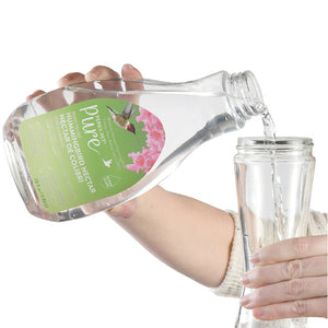 Person pouring Perky-Pet® Pure Ready-to-Use Clear Hummingbird Nectar, 28 oz., from a bottle into a glass, emphasizing ease of use and bird-friendly formula.