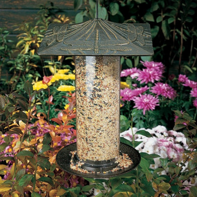 Whitehall Dragonfly Tube Bird Feeder filled with seeds, featuring a durable, rust-proof finish and a metal hanger for easy outdoor placement.