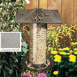 Trumpet Vine Tube Bird Feeder with seed, featuring a clear tube, rust-proof copper verdi finish, and a metal hanger for easy tree branch mounting.