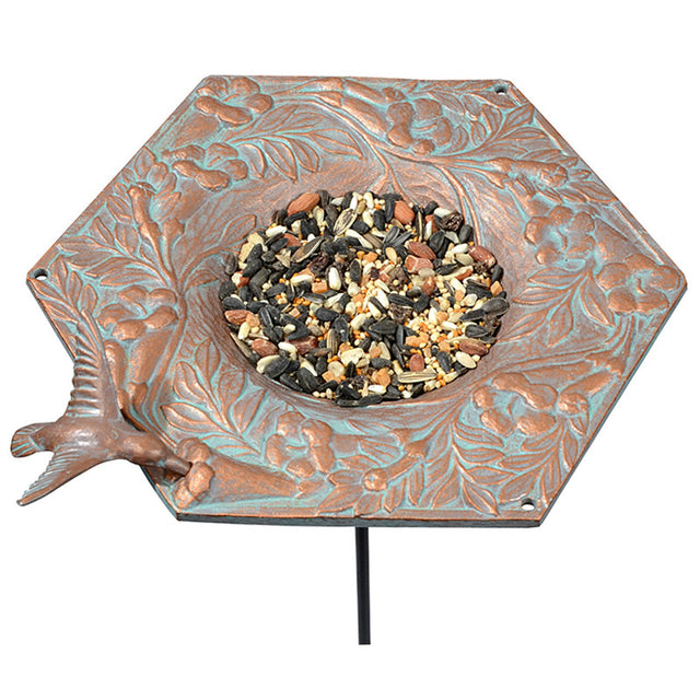 Hummingbird Garden Bird Feeder with bird food, hand-cast metal design featuring a hummingbird, wide rim, copper verdi finish, and metal stake for easy installation.