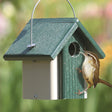 Duncraft Eco-Friendly Wren House with bird perched on entrance, featuring a 1-1/4 inch entry hole and wire hanger.