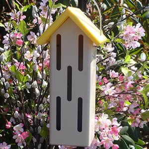 Eco-Butterfly House with yellow roof, featuring slotted entry openings for butterflies to seek shelter from weather, made from recycled plastic with a wire hanger.