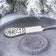 Deluxe Birdbath Heater on a concrete surface. Close-up of stainless steel housing and circular design, ideal for keeping birdbath water ice-free in cold weather.
