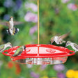 Aspects HummZinger Excel hummingbird feeder with six feeding stations and wraparound perch, showing multiple hummingbirds feeding.