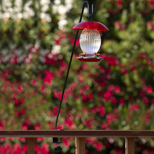 Clamp-On Deck Hook mounted on a railing, ideal for hanging bird feeders, extends 13 inches outward, fits railings up to 2 inches, and supports up to 10 lbs.