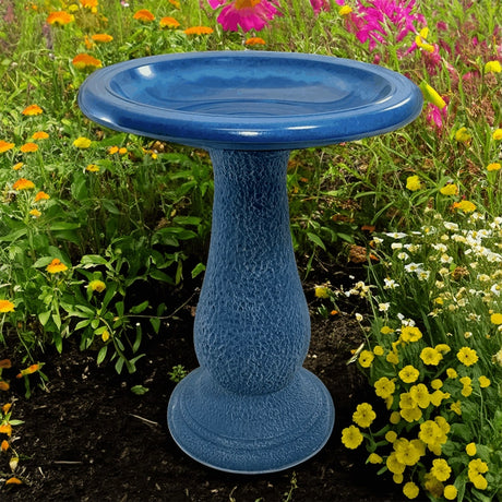 Navy Blue Fiber Clay Bird Bath in a garden setting, featuring a 19-inch diameter basin, ideal for attracting birds. Lightweight and easy to move.