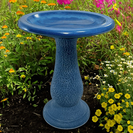 Navy Blue Fiber Clay Bird Bath in a garden setting, featuring a 19-inch diameter basin, ideal for attracting birds. Lightweight and easy to move.