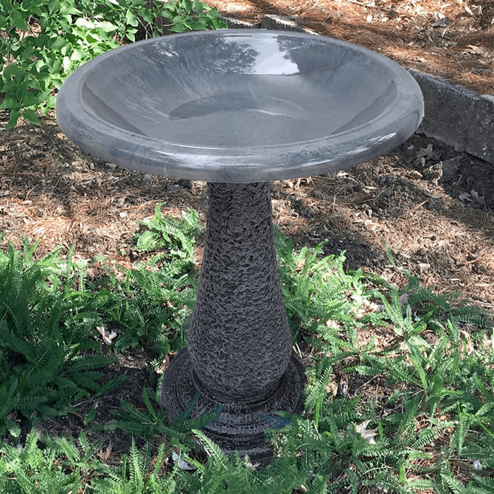 Cool Grey Fiber Clay Bird Bath in a garden, featuring a sloping basin for easy bird viewing, set on a matte finish pedestal.