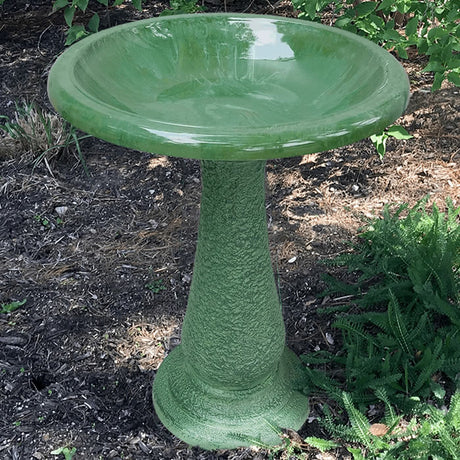 Kale Green Fiber Clay Bird Bath with a sloping 19-inch basin on a 24-inch pedestal, set in an outdoor garden.