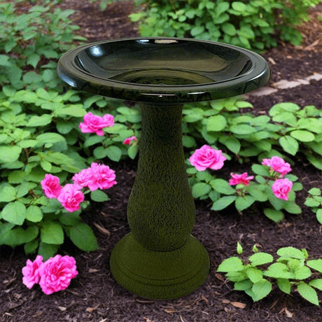 Birds & Beyond Fiber Clay Bird Bath, Hunter Green, featuring a stone pedestal with a full-sized basin, placed in a lush garden setting.