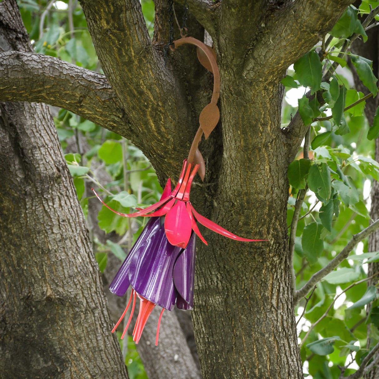 Fuchsia Hummingbird Feeder, crafted from plastic bags, features a flower design with long trailing pistils and includes an 8 oz. nectar bottle and hanging chain.