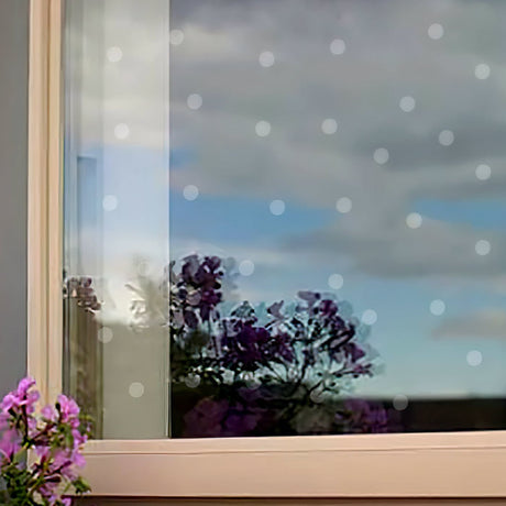 UV Liquid, 1.5 oz. Bottle, shown near a window with purple flowers, designed to prevent bird strikes by filling gaps between window decals with clear dots.