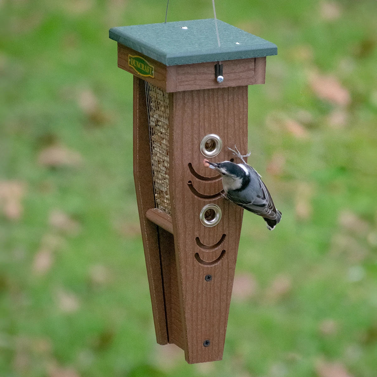 Duncraft Woodpecker Mesh Feeder with birds feeding from grooved perches, featuring a durable design with mesh sides and four feeding ports.