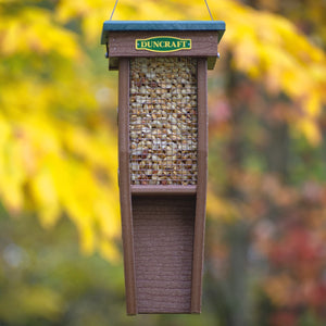 Duncraft Woodpecker Mesh Feeder, hanging from a tree, filled with peanuts, featuring mesh sides and grooved perches for birds to cling during feeding.