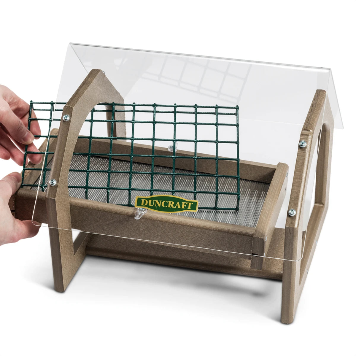 Hand holding the Duncraft Universal Seed Saver Platform Feeder, showcasing the wire mesh cage and perforated aluminum bottom for excellent drainage.