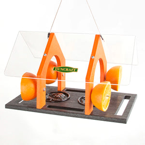 Duncraft Super Sized Oriole Feeder with orange slices and two dishes for jelly or suet, featuring a large roof and built-in perches.