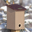 Duncraft Premium Eco-Strong Roost House with a sparrow perched on the wooden birdhouse, featuring a 1-1/2 inch entry hole and a ladder inside.