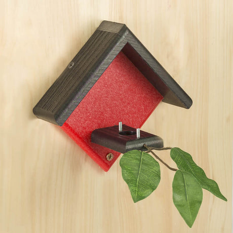 Duncraft Little Red Hummingbird House mounted with a plant, featuring two metal posts for nest support and a landing branch with leaves.