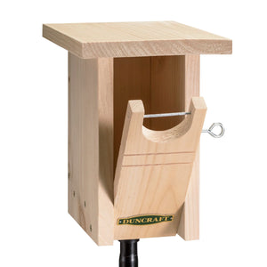 Duncraft Gilwood Bluebird Nest Box Bird House & Pole: A wooden birdhouse with an oval entry hole, designed to discourage sparrows and keep the nesting area dry.